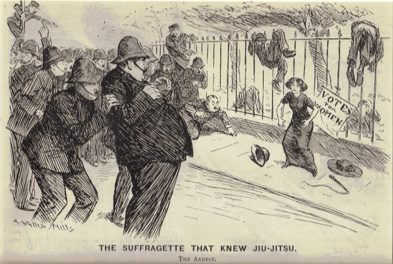 Karikatur von Arthur Wallis Mills, 1910: Eine einzelne Frau steht vor einem Votes-for-Women-Plakat, um sie herum liegen und hängen mehrere Polizisten, weitere halten Abstand; Bildtitel The Suffragette that Knew Jiu-Jitsu