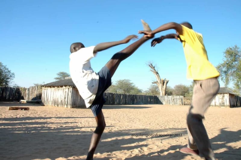 Engolo-Spieler in Angola, der linke führt einen hohen frontalen Halbmondtritt aus