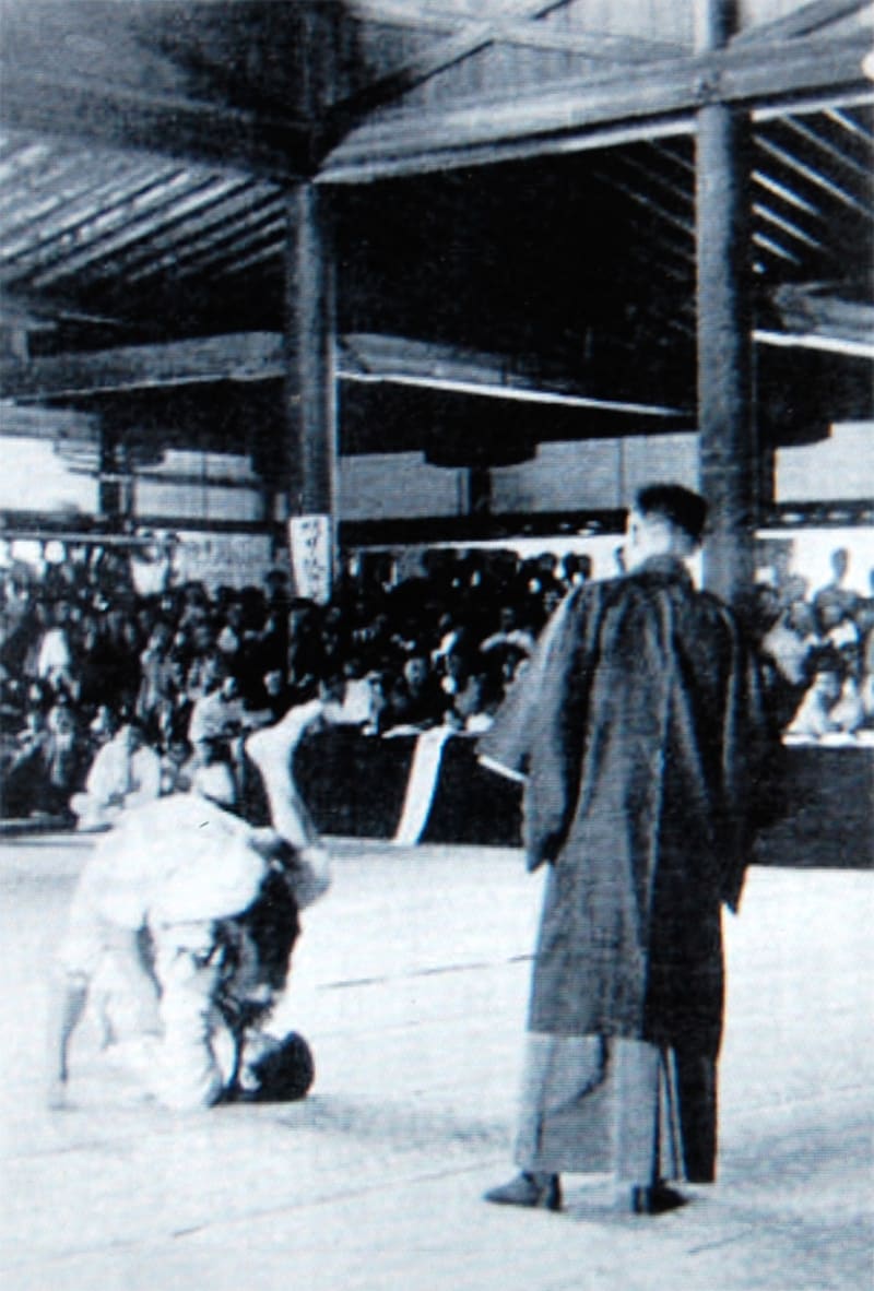 Zeitungsaufnahme der 1920er Jahre: Bodenkampf bei einem Kosen-Judo-Wettkampf in einer Holzhalle, Kampfrichter im Kimono, dichtes Publikum ringsum