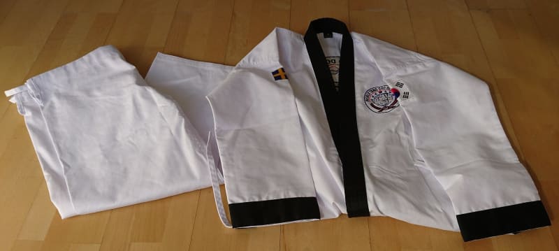Dobok mit schwarzem Gürtel, die Trainingskleidung des Tang Soo Do