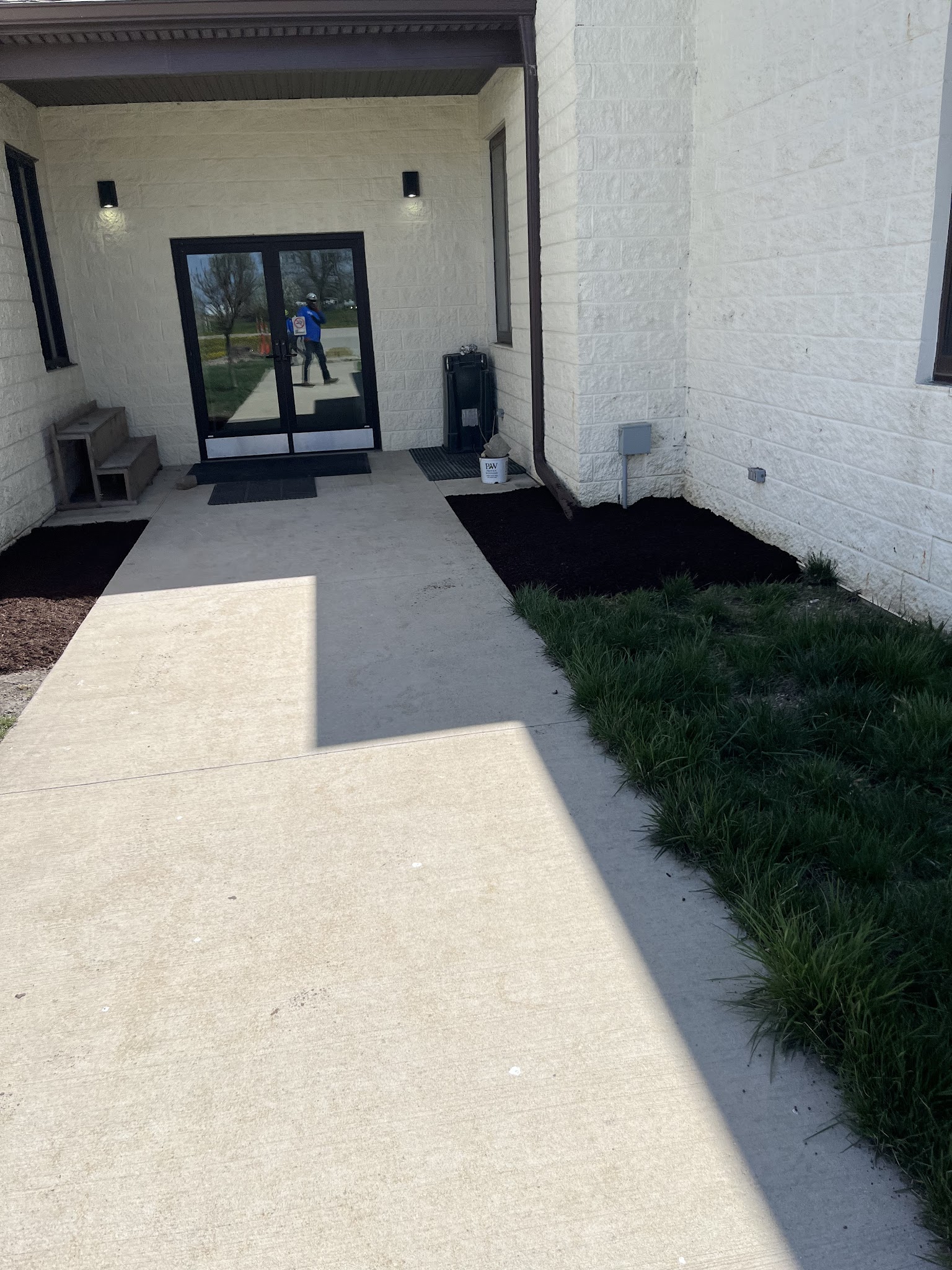 Fresh mulch beds and walkway at a commercial entrance in Urbana, IL