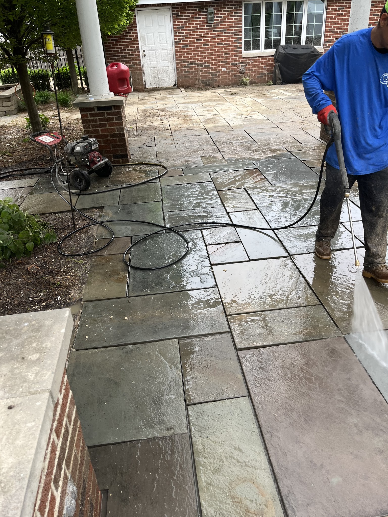 M.A.D Landscape crew pressure washing a flagstone patio in Urbana, IL