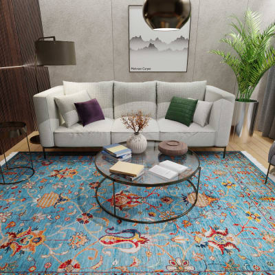 Mehreen Carpets Dubai Mall: Elegant room with a colorful blue floral carpet, modern sofa, glass table, and decor accents.