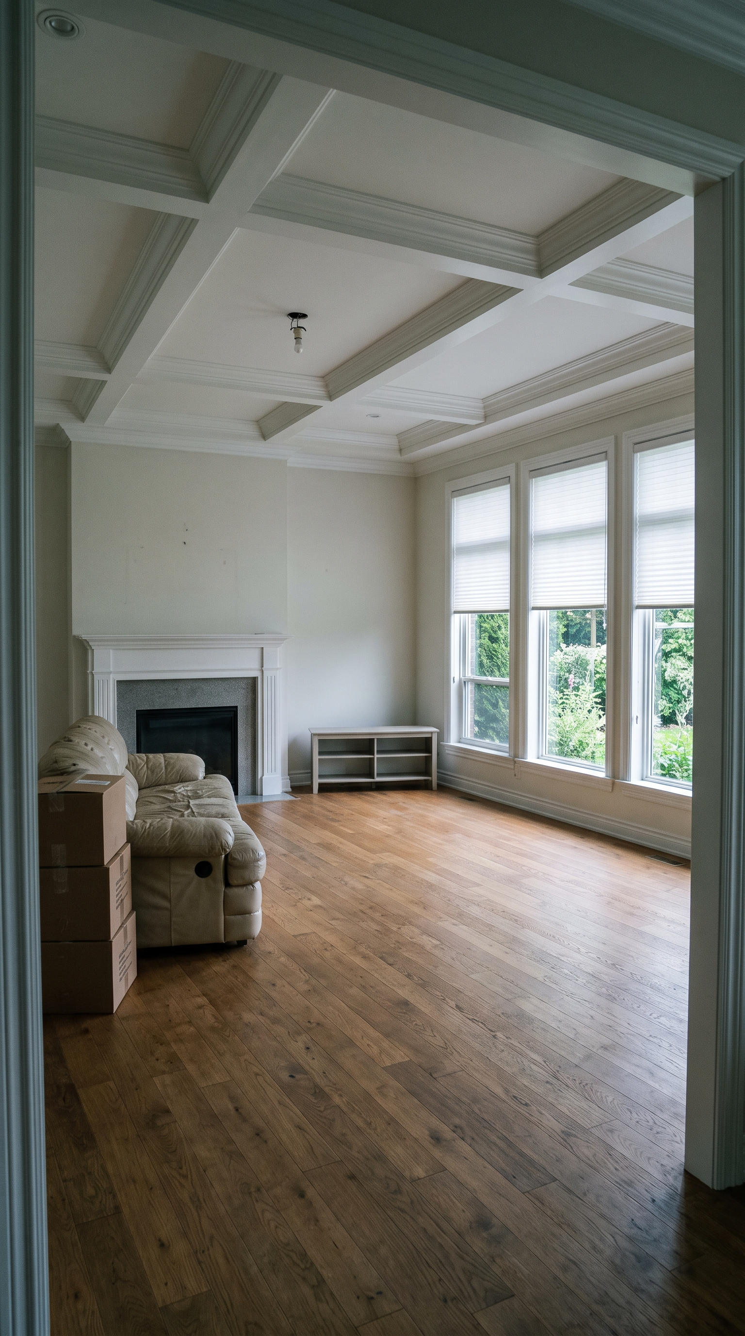 Before: an empty Connecticut country house living room with a coffered ceiling, marble fireplace, and walnut floors