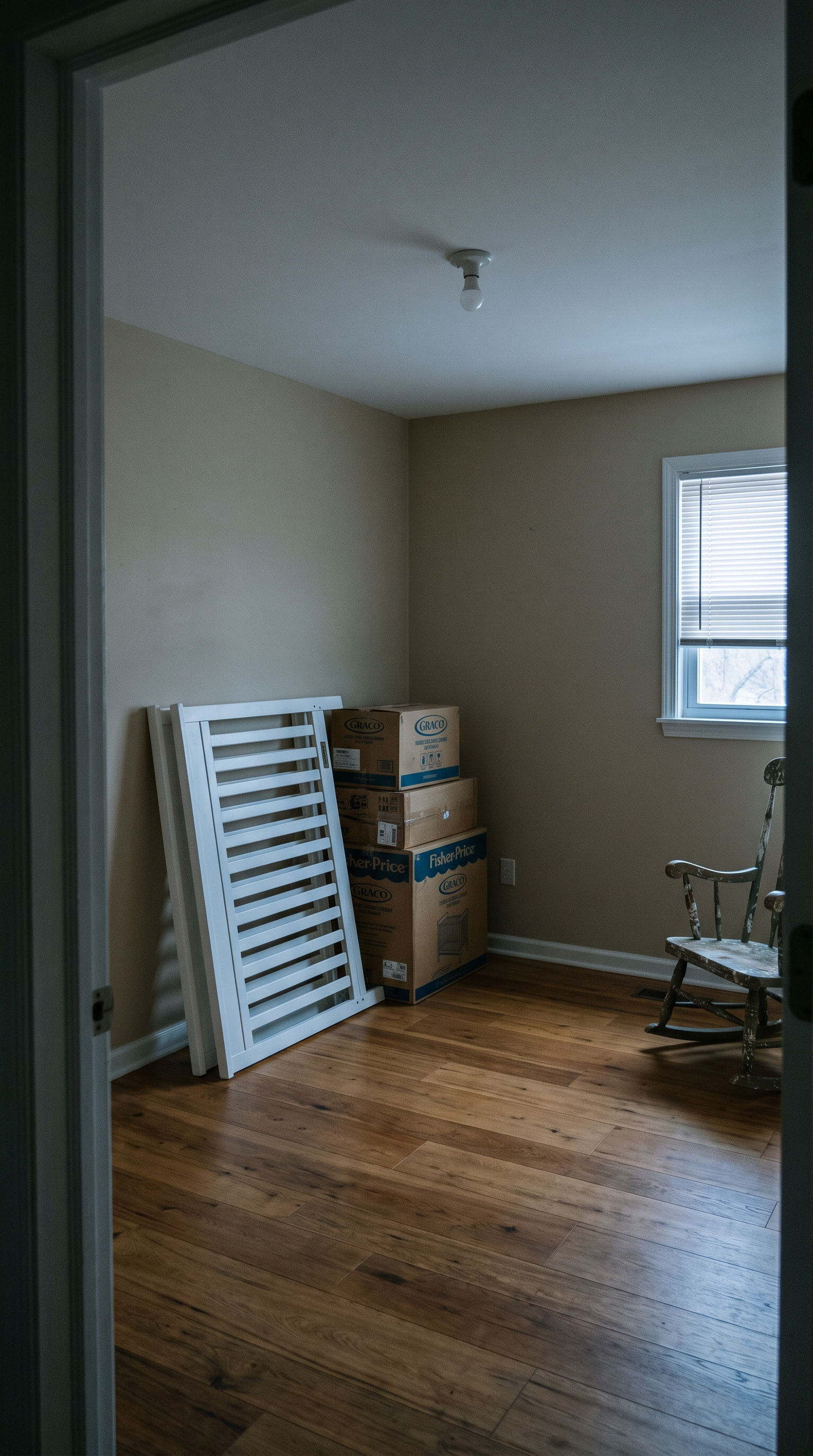 Before: a spare room turned nursery-in-waiting with an unassembled white crib, moving boxes, and a distressed old rocking chair