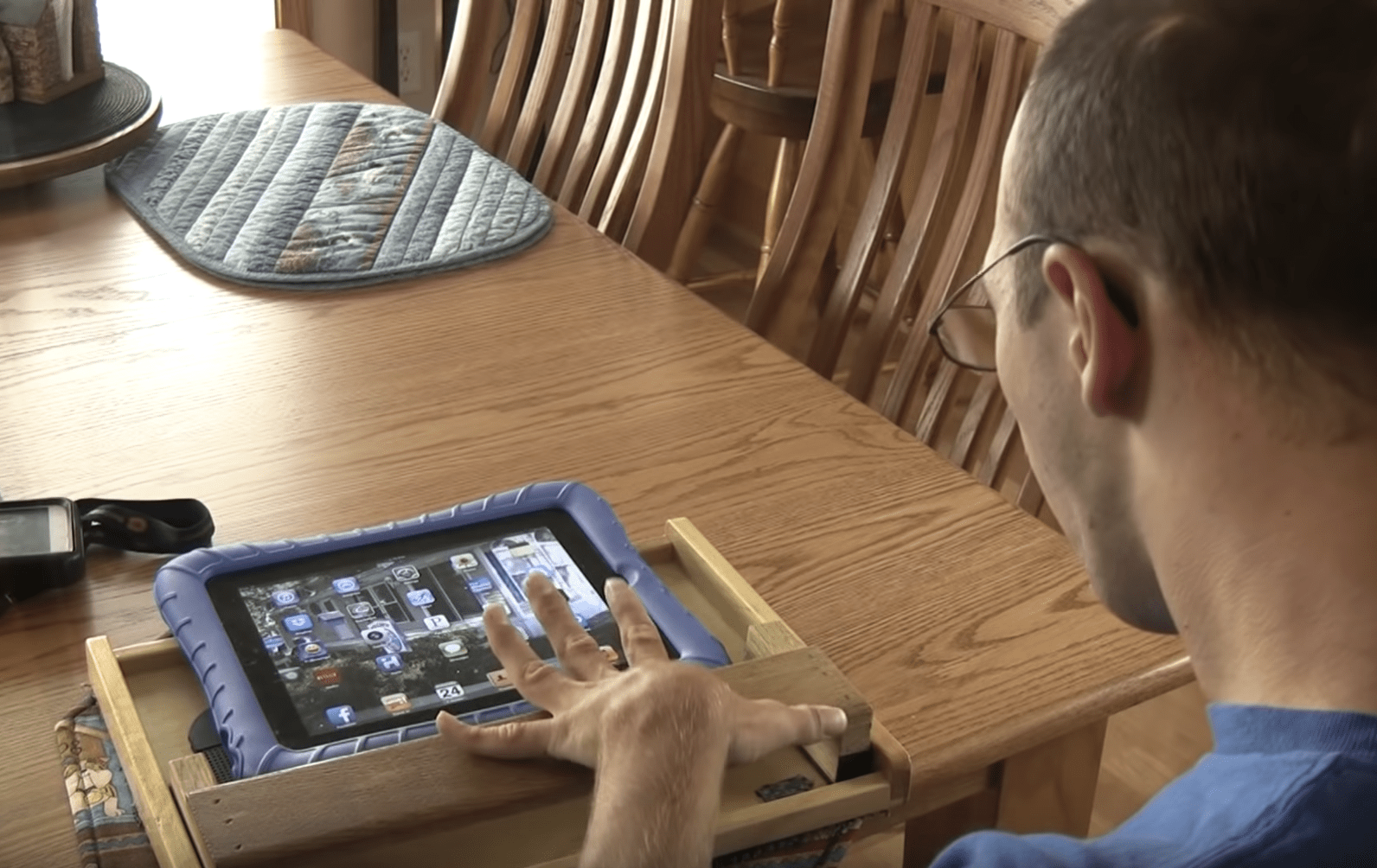 A user with a slide board fitted over the top of an iPad