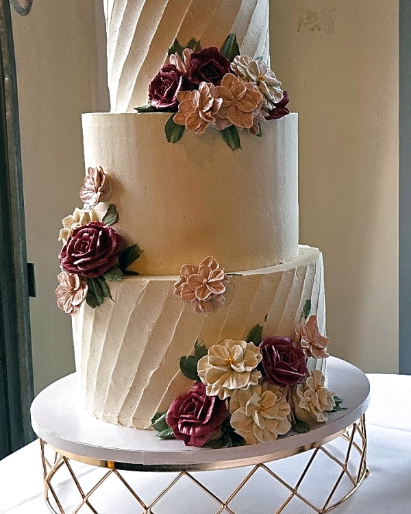 Wedding cake by Sweet E's Bakery in Brighton, a four-tier wedding cake with a smooth buttercream finish and diagonal textured buttercream on