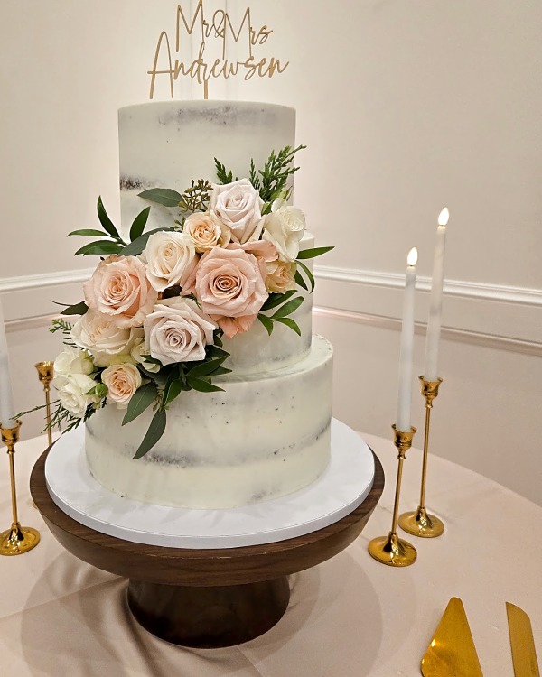 Twenty & Creek wedding cake, three-tier semi-naked cake with fresh floral cascade in blush, cream, and green