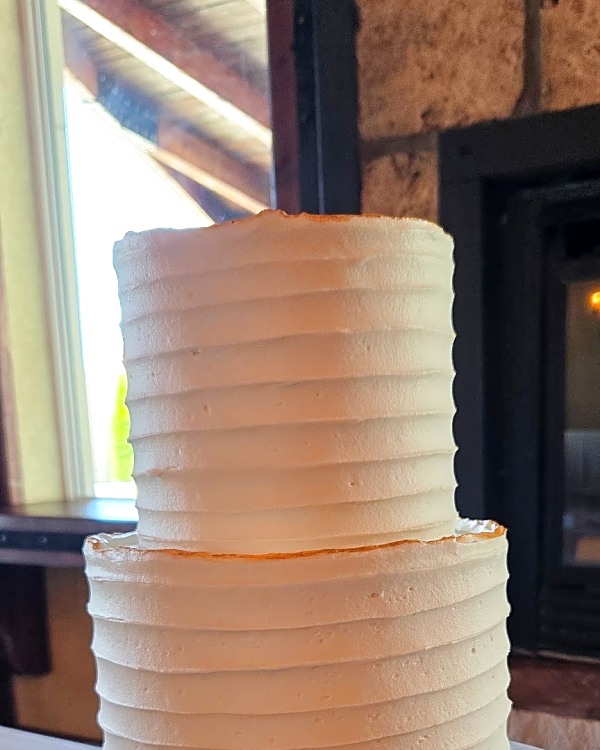 Wadley Farms wedding cake, two-tier white buttercream cake with horizontal ridged texture and gold trim at the base of the top