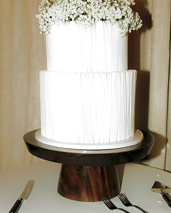 Berkeley and Jarom's winter wedding cake, white vertical piped texture with a crown of baby's breath, Sundance, Utah