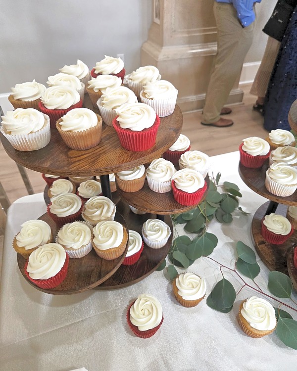 Wedding cupcakes with white frosting on tiered wooden stands at Sleepy Ridge