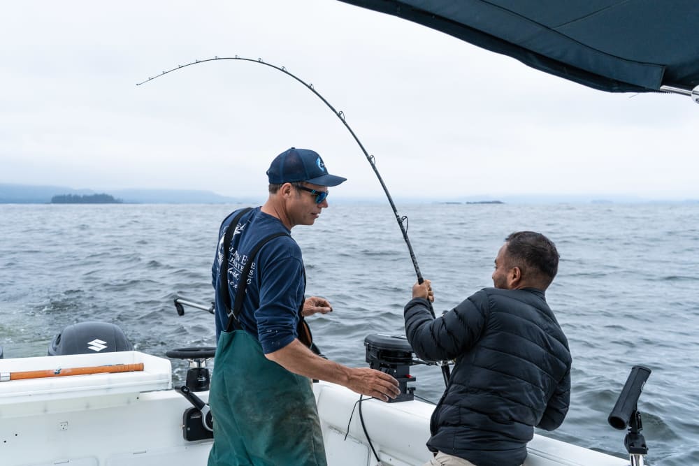 Guide coaching an angler fighting a fish