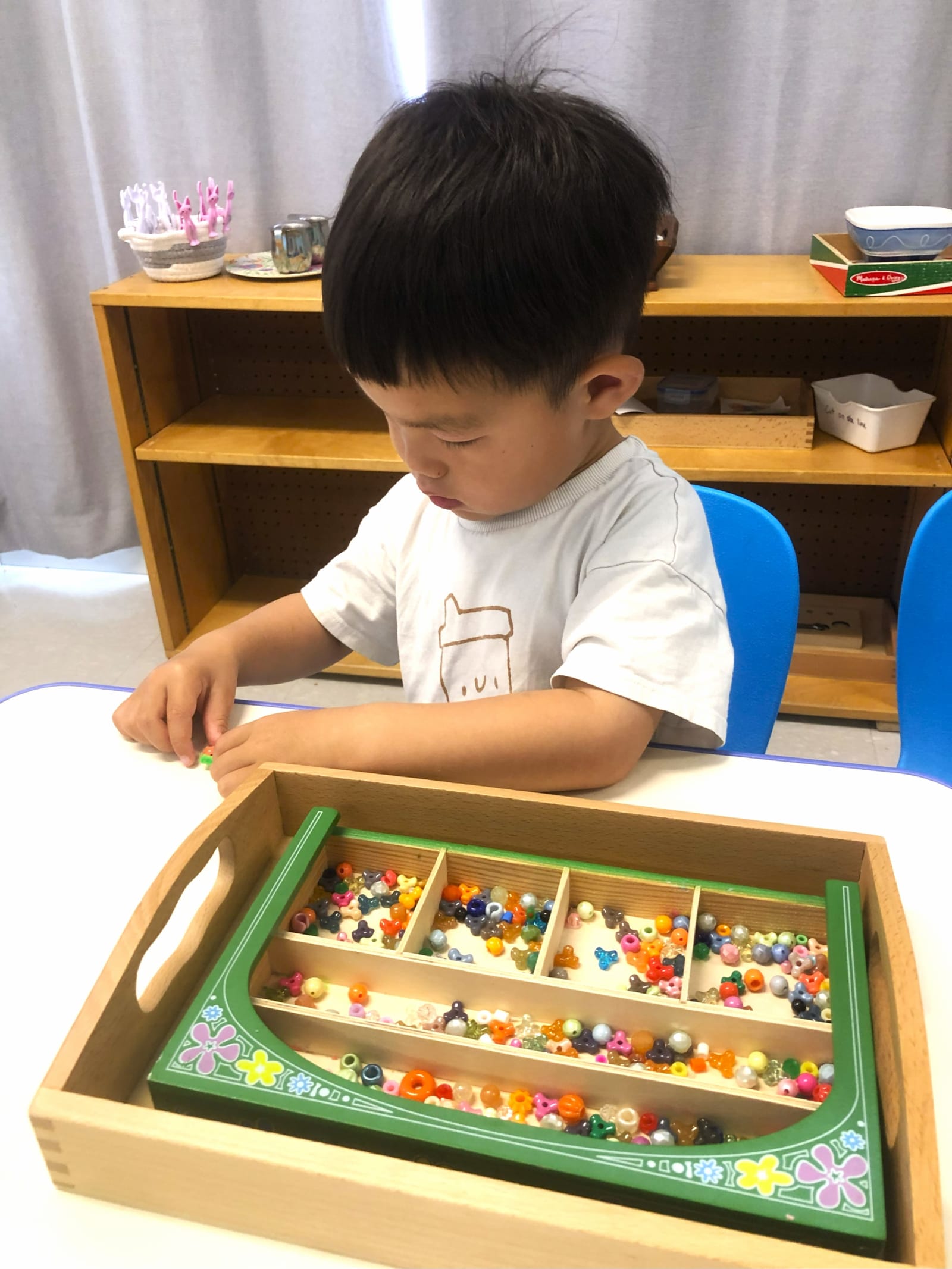 Garderie Ami Câlin — activité sensorielle Montessori : guidé par l'éducatrice, un enfant manipule des perles colorées pour associer les quantités et pratiquer le comptage dans un environnement chaleureux. Inscriptions en cours. — Garderie Ami Câlin — Exercice Montessori de comptage avec perles — Mots-clés : Garderie Ami Câlin, Montessori, activité avec perles, comptage mathématique, garderie Gatineau, inscriptions.