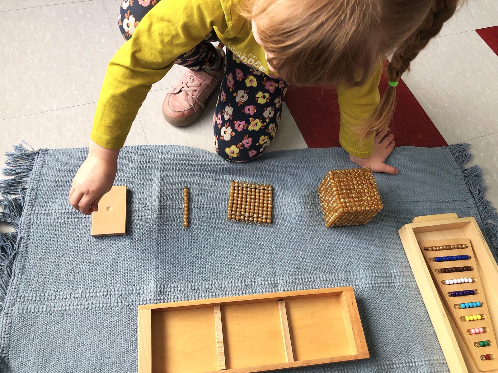 Garderie Ami Câlin — initiation aux mathématiques Montessori : un enfant apprend les quantités unités, dizaines, centaines et milliers avec les perles dorées, pour développer une logique mathématique concrète. Garderie à Gatineau, inscriptions en cours. — Garderie Ami Câlin — Mathématiques Montessori avec perles dorées — Mots-clés : Garderie Ami Câlin, mathématiques Montessori, perles dorées, développement logique, garderie Gatineau, inscriptions.