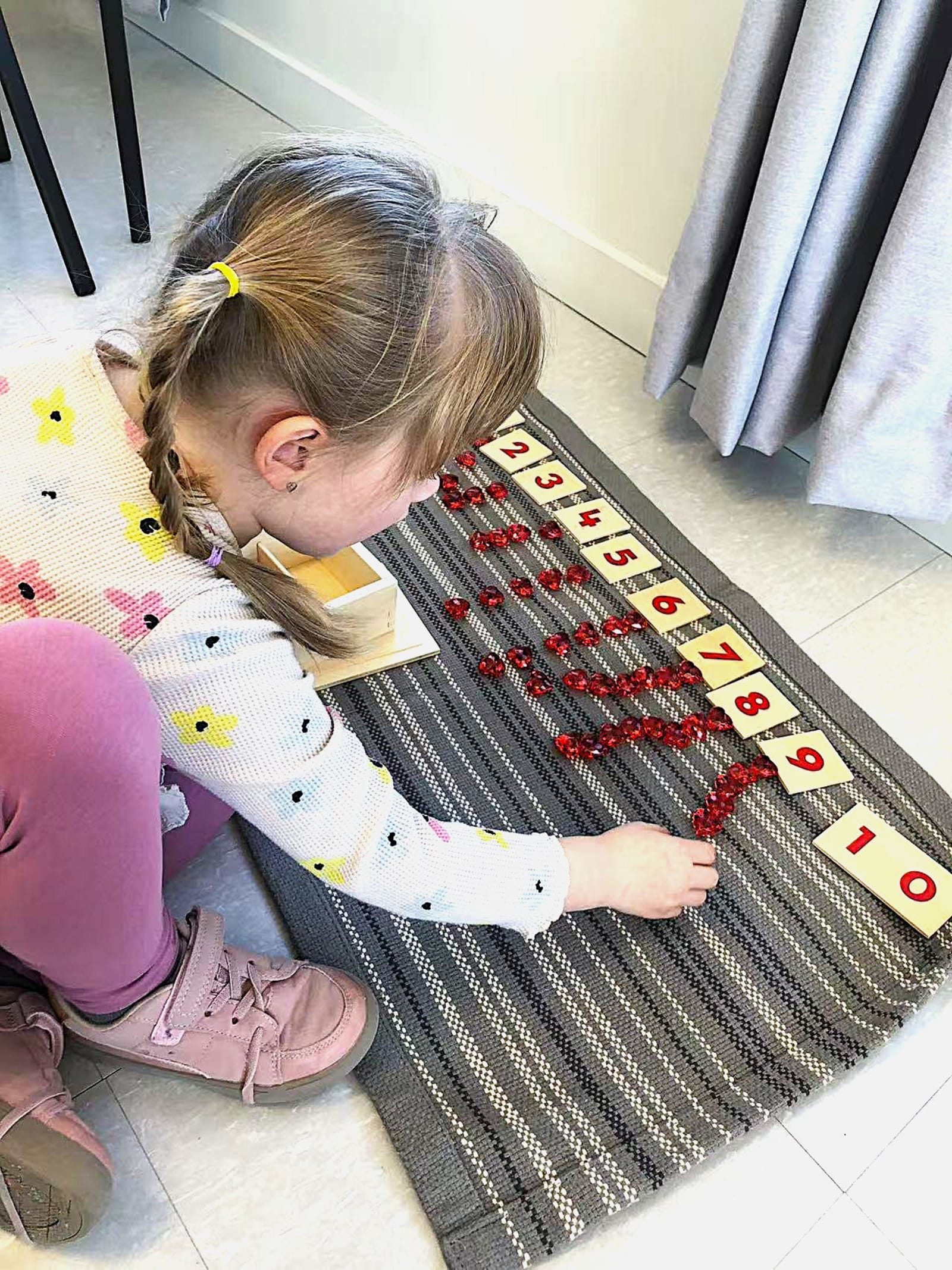 Garderie Ami Câlin — activité Montessori de mathématiques : un enfant associe chiffres et jetons pour comprendre concrètement les nombres pairs et impairs ainsi que la correspondance des quantités. Inscriptions ouvertes à Gatineau. — Garderie Ami Câlin — Mathématiques Montessori : chiffres et jetons — Mots-clés : Garderie Ami Câlin, mathématiques Montessori, comptage en petite enfance, inscriptions, garderie Gatineau, éducation préscolaire.