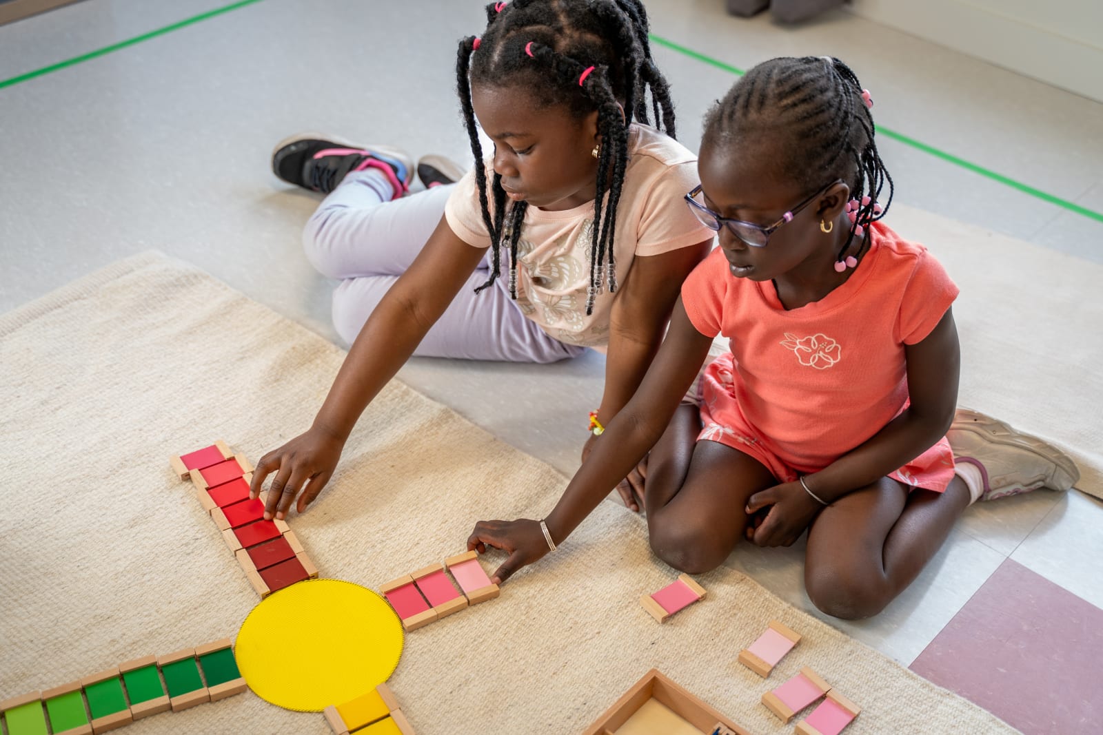 Garderie Ami Câlin : deux enfants travaillent ensemble avec du matériel Montessori de couleurs, renforçant l'attention, la collaboration et la résolution de problèmes.