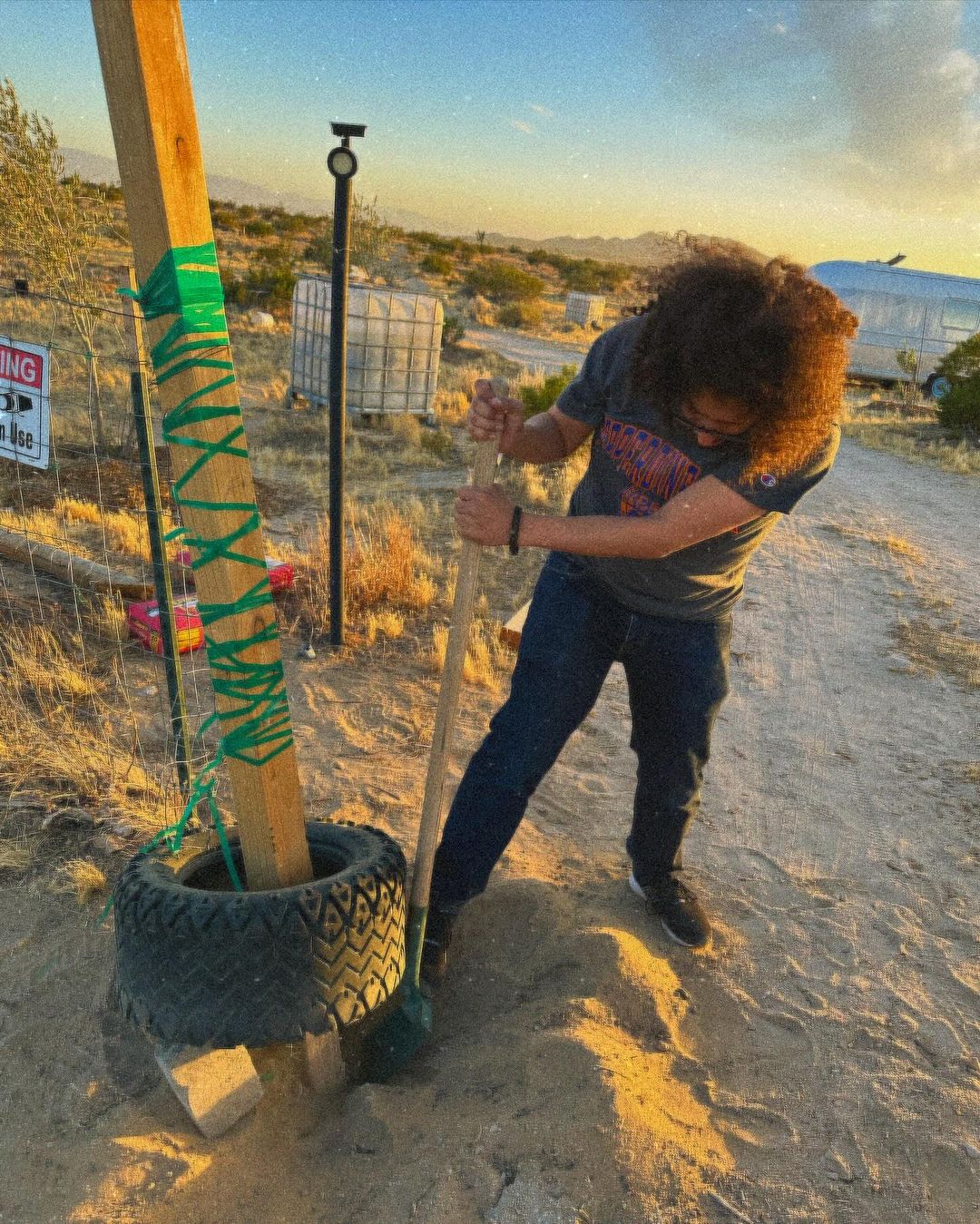 Volunteer Earthworker fixing the entry gate and fence at For Every Star, A Tree: the Tiny Forest in the Desert