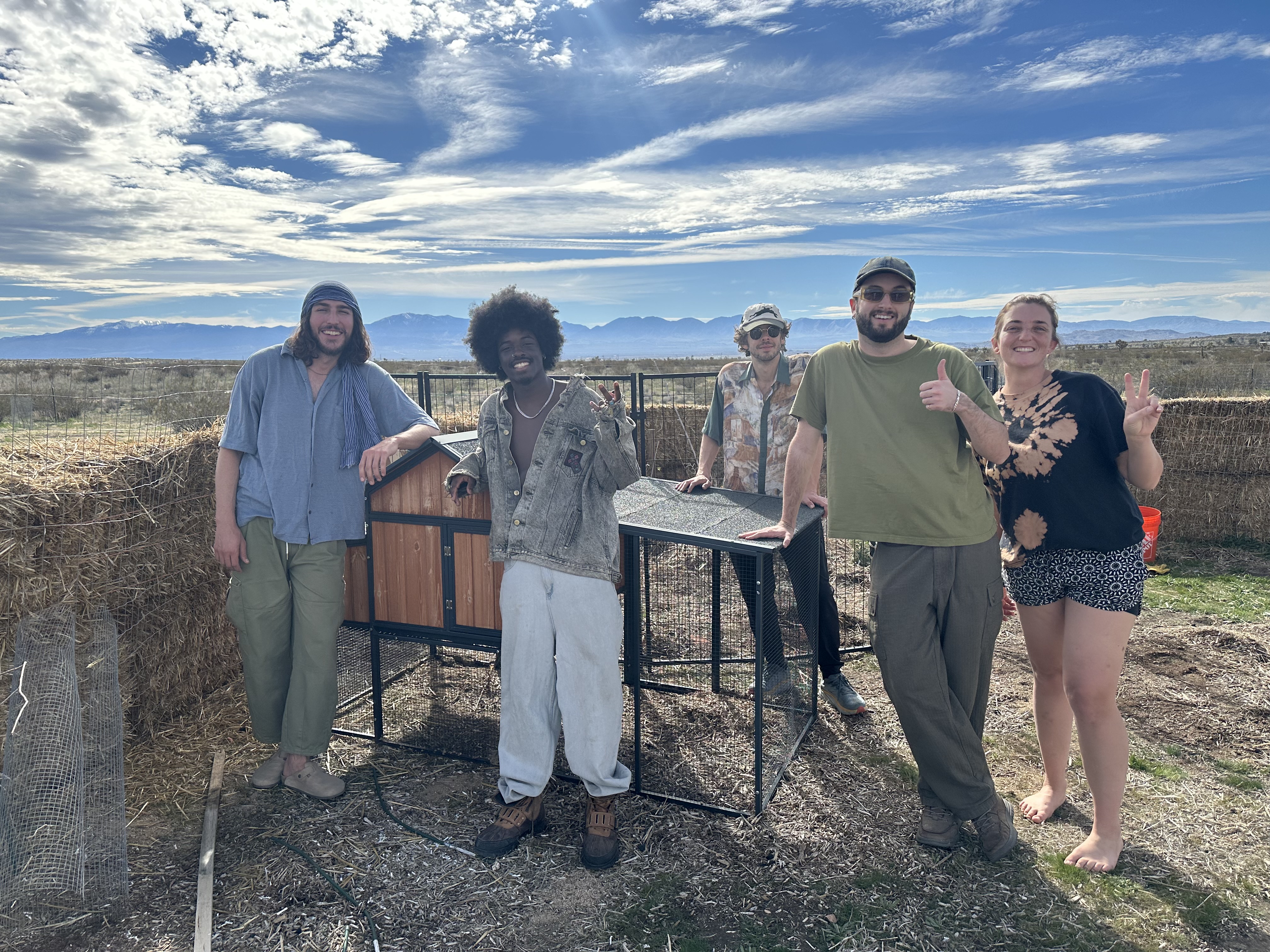 Volunteer Earthworkers moving the chicken coop at For Every Star, A Tree: Tiny Forest in the Desert