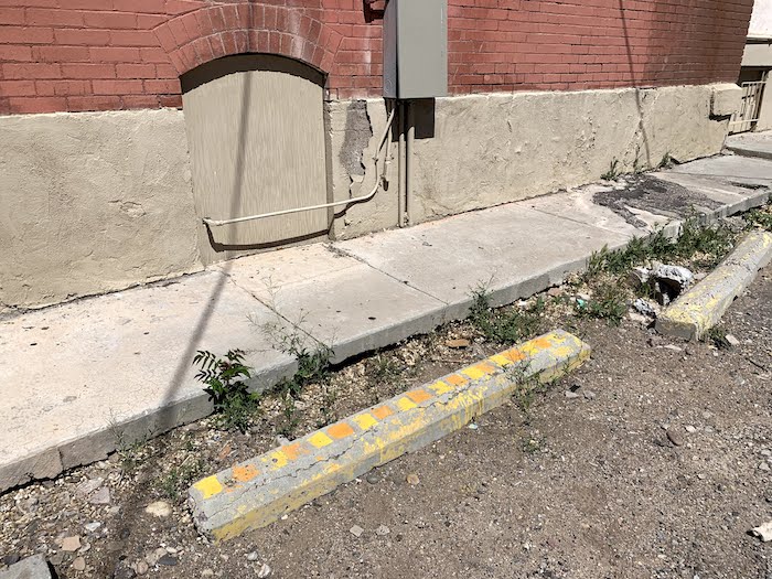 parking lot with concrete car park bumper painted with orange and yellow squares