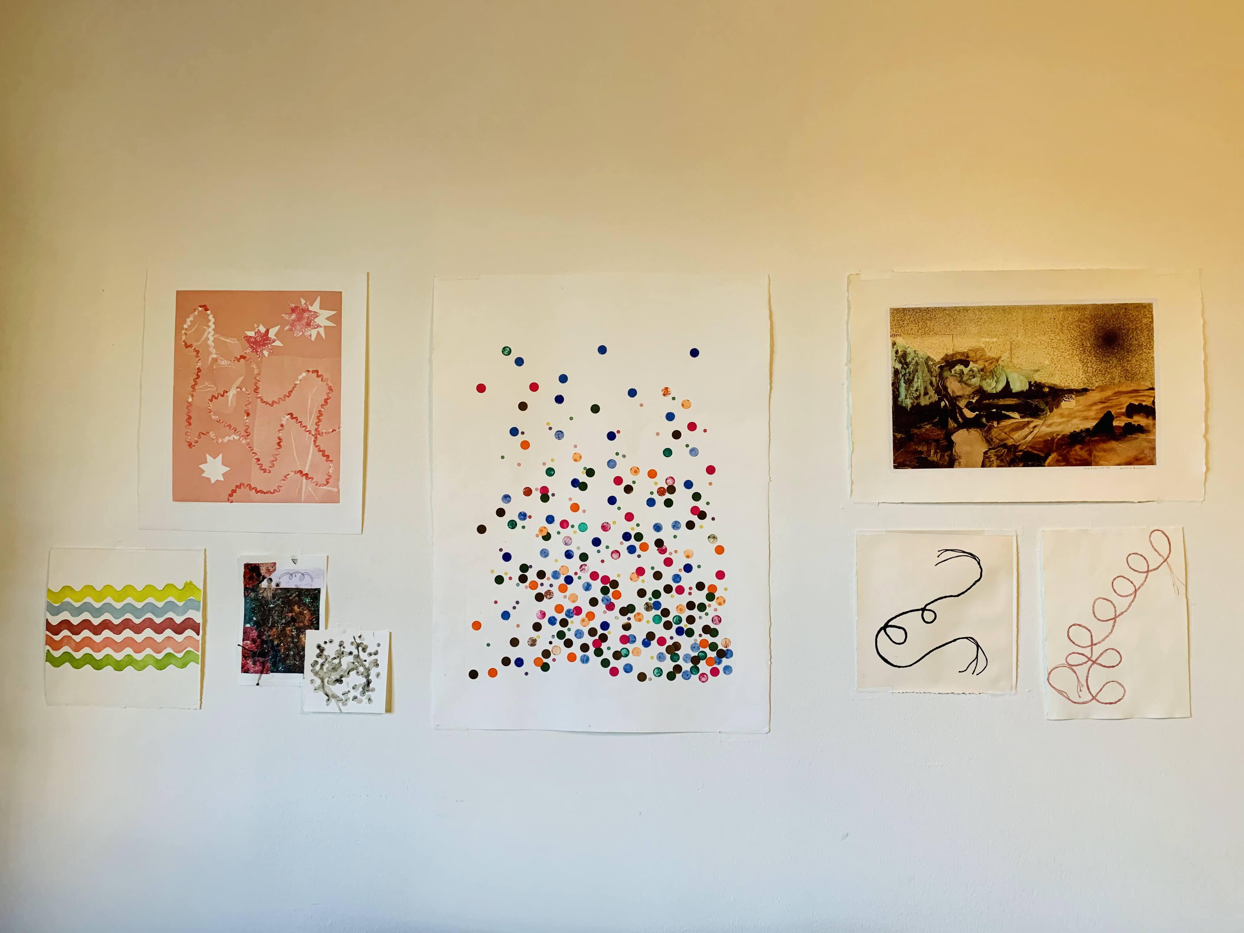 wall containing prints and mixed media pieces