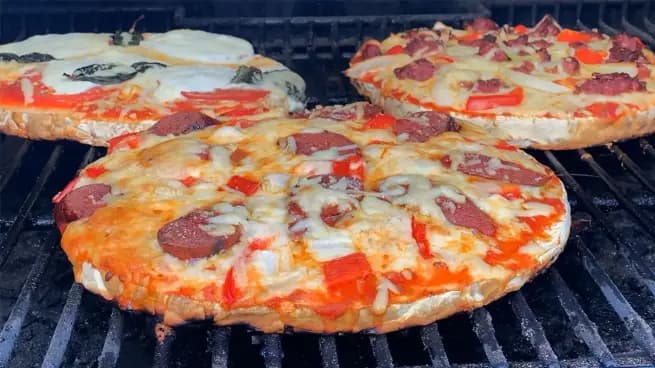 three puffball mushroom pizzas on grill