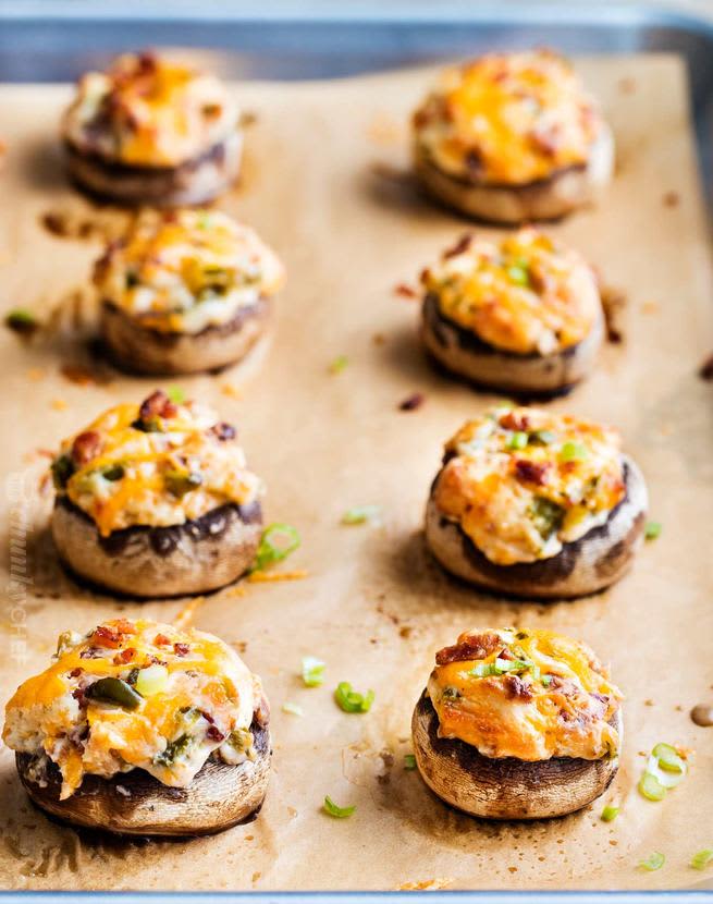 jalapeno popper stuffed mushrooms on hot baking sheet with parchment paper