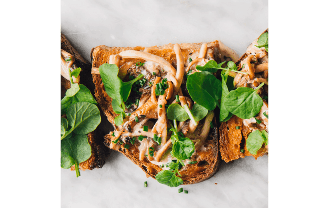 Mushroom toast topped with watercress and chives.