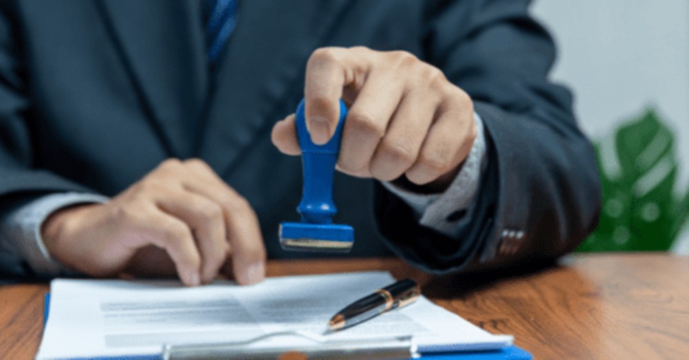 man applying visa stamp on application