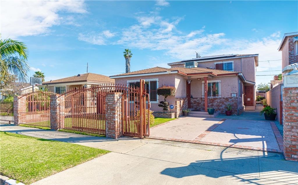 Single family home with wrought iron gate and brick pillars in South Los Angeles