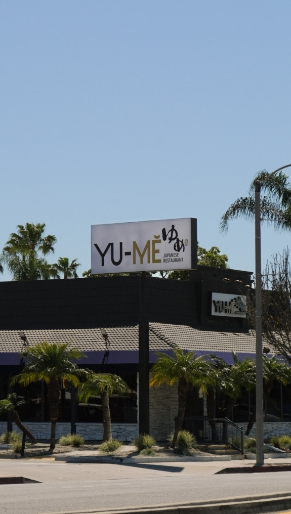 Storefront view of the original Yume Japanese Restaurant in Pico Rivera, California with warm interior lighting visible through the entrance