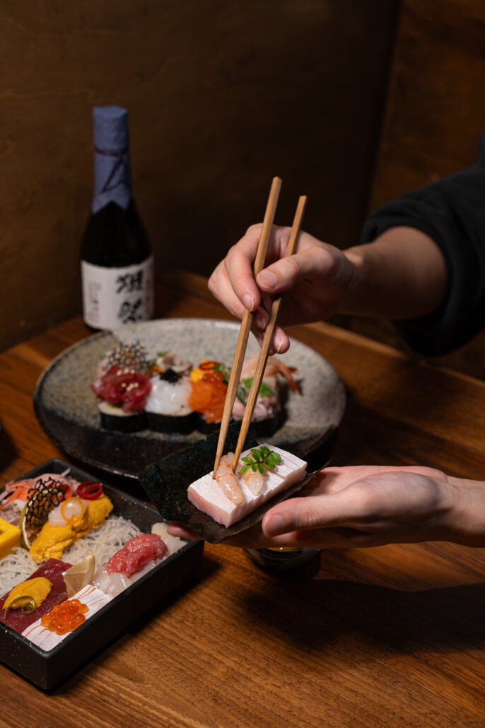 A colorful assortment of freshly prepared sushi rolls and nigiri served on a wooden platter at Yume Pico Rivera