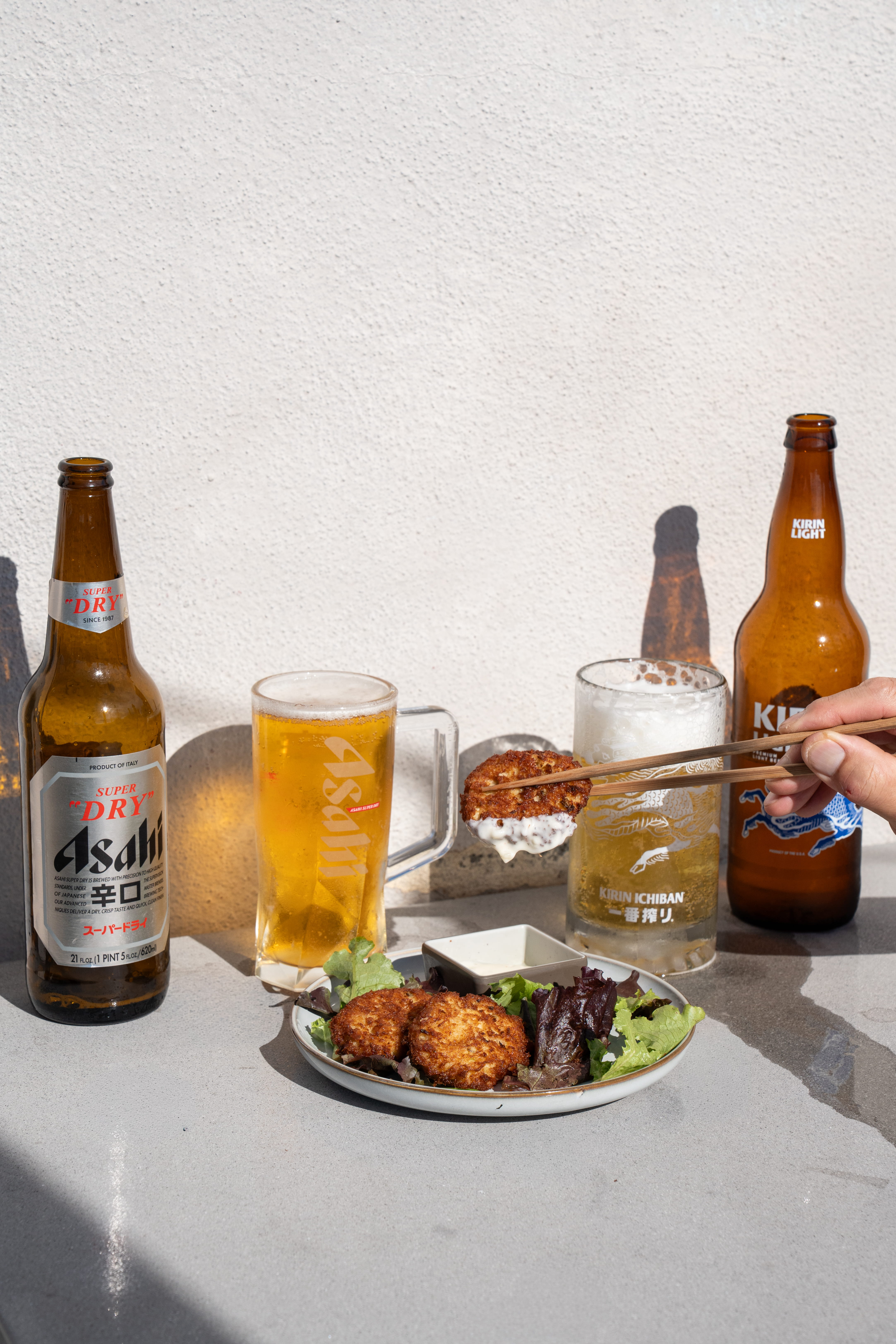 Japanese beer bottles and appetizer dishes on a dining table at Yume Manhattan Beach, blending California beach culture with Japanese cuisine
