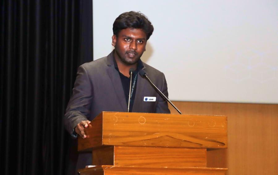 Jayanth Ramakrishnan delivering a talk at a podium