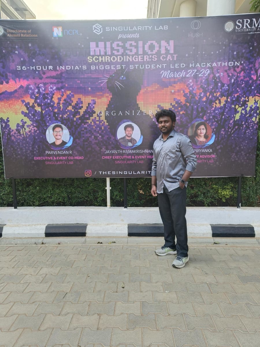 Jayanth Ramakrishnan in front of the MISSION: Schrödinger’s Cat hackathon poster