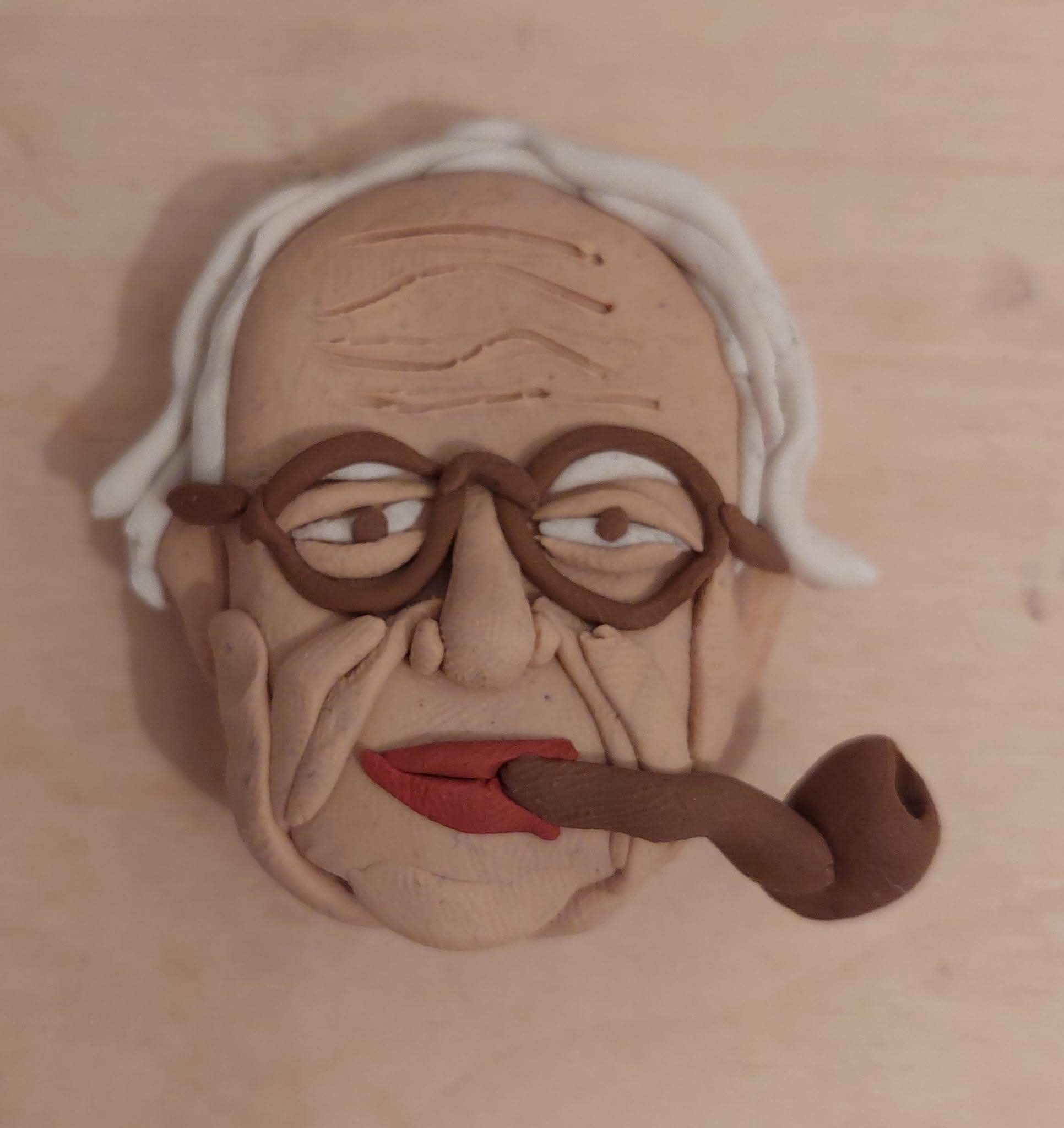 דמות פלסטלינה של גיבור-על עם גלימה אדומה, המפגינה טכניקת פיסול ועיצוב.