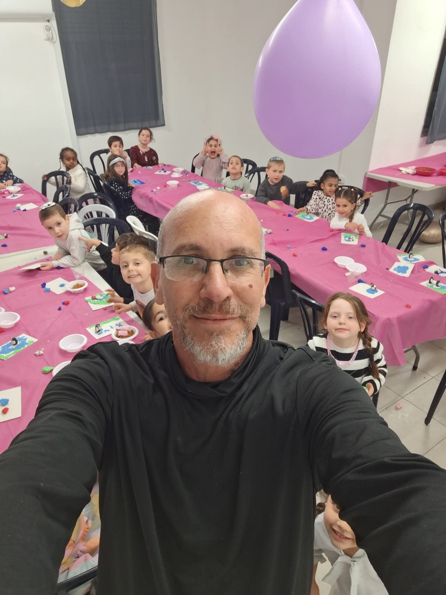 שניר פלג מדגים לילדים כיצד ליצור דמויות פלסטלינה במהלך סדנת יום הולדת.