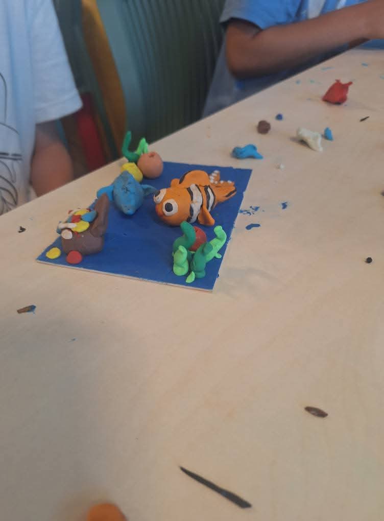 פיסול פלסטלינה של דמות מורכבת עם אביזרים רבים, כמו כובע, חרב ותיק, המדגים מיומנות גבוהה.