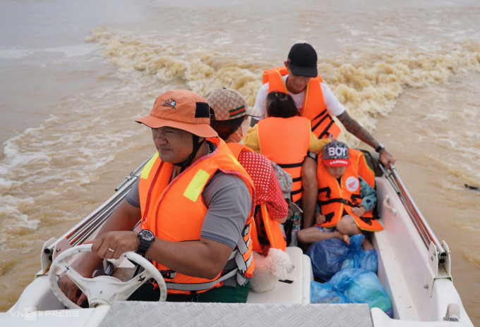 Anh Trung lái xuồng cứu hộ đưa một gia đình thoát khỏi ngập sâu ở Nam Phước, cách Hội An khoảng 7 km trong đợt lụt cuối tháng 10 ở miền Trung. Ảnh: Nguyễn Đông