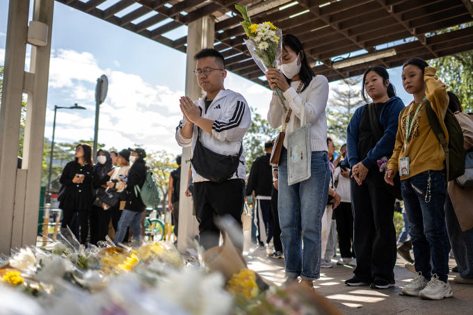 Người dân đặt hoa tưởng niệm các nạn nhân vụ cháy cụm chung cư Wang Fuk Court tại khu vực tưởng niệm ngày 29/11. Ảnh: AFP