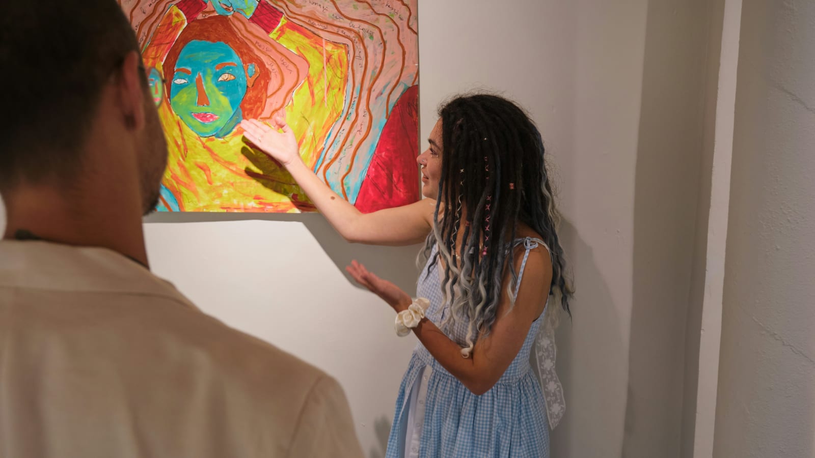Gallery opening — guests embracing in front of artwork