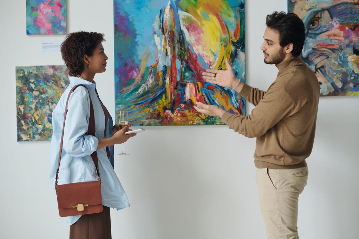 Man and woman discussing art at gallery opening ⚠ WATERMARK
