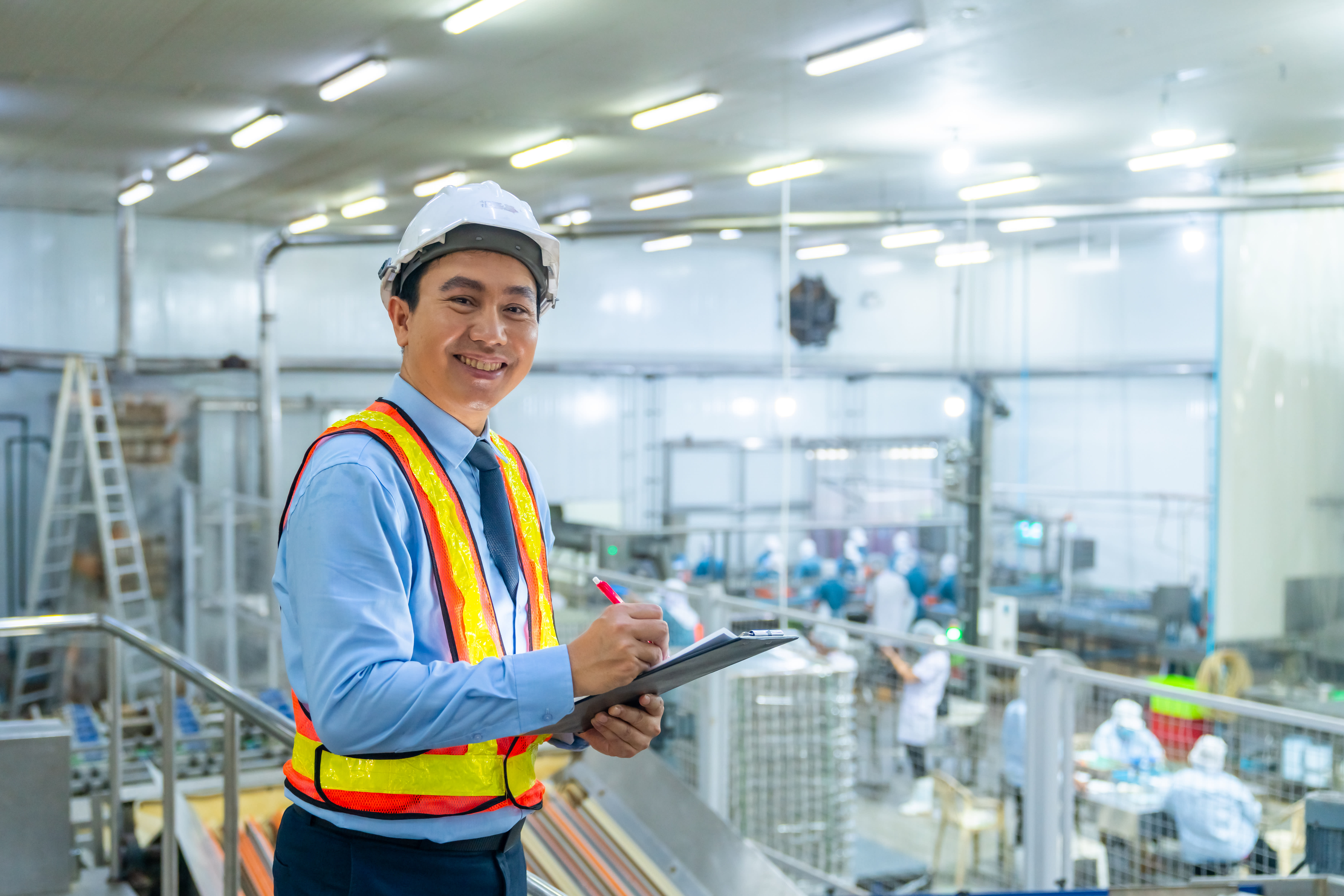 A food factory owner smiling proudly in front of a new factory