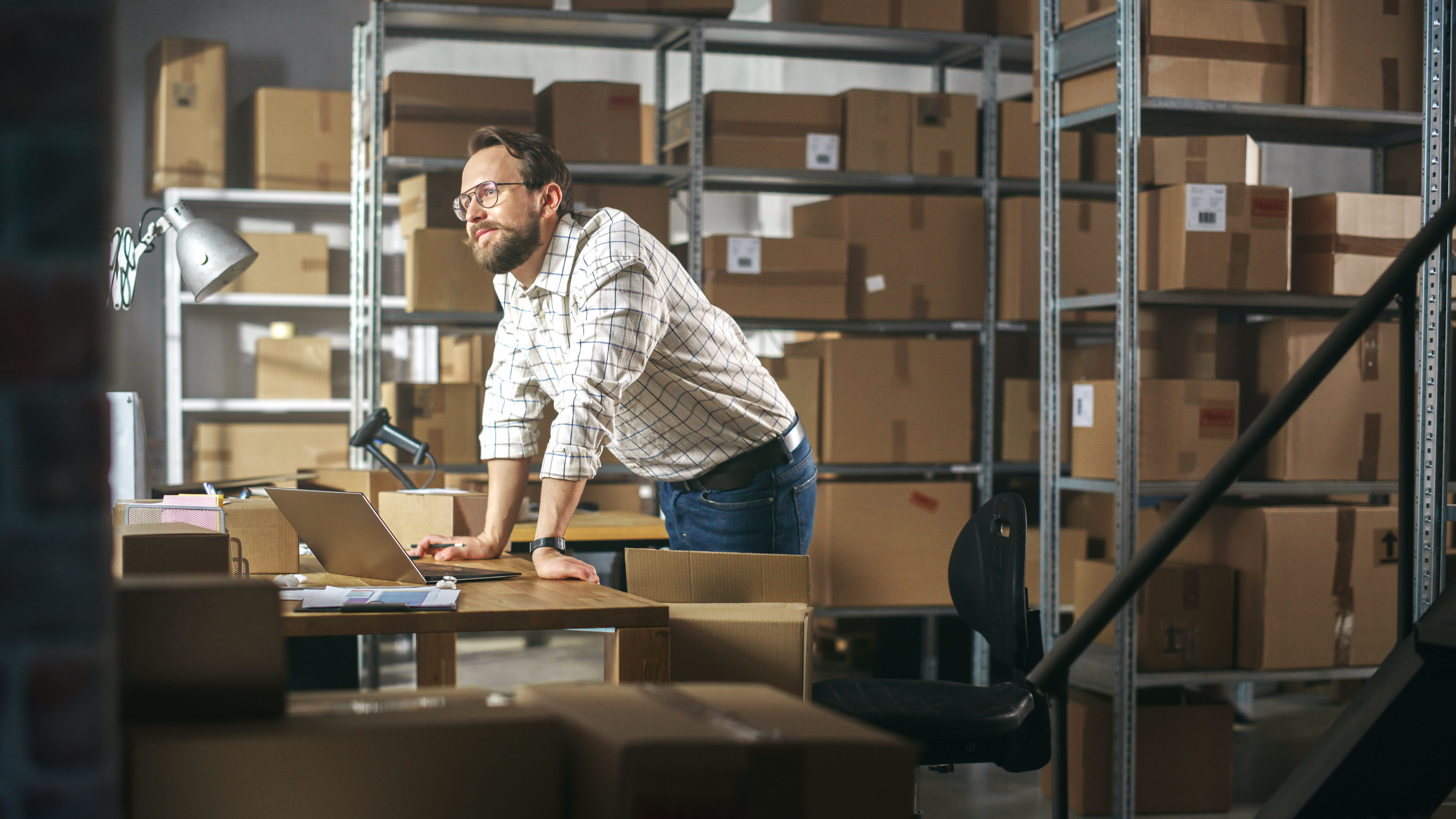 A man looking out over a warehouse, contemplative and forward-looking