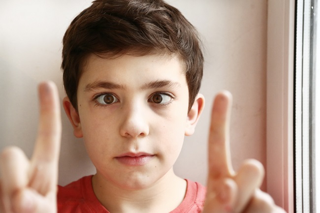 preteen handsome boy play squinting trick