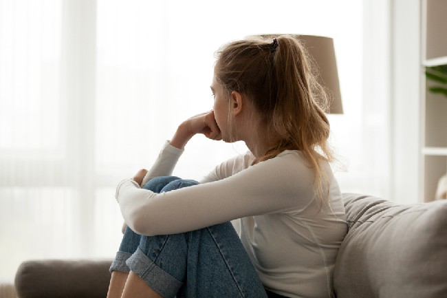 Side,View,Young,Woman,Looking,Away,At,Window,Sitting,On