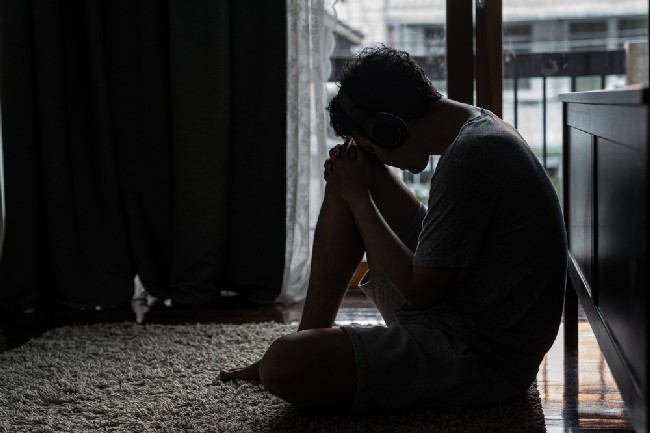 Wide,Shot,Young,Adult,Asian,Loneliness,Sad,Man,Sitting,On