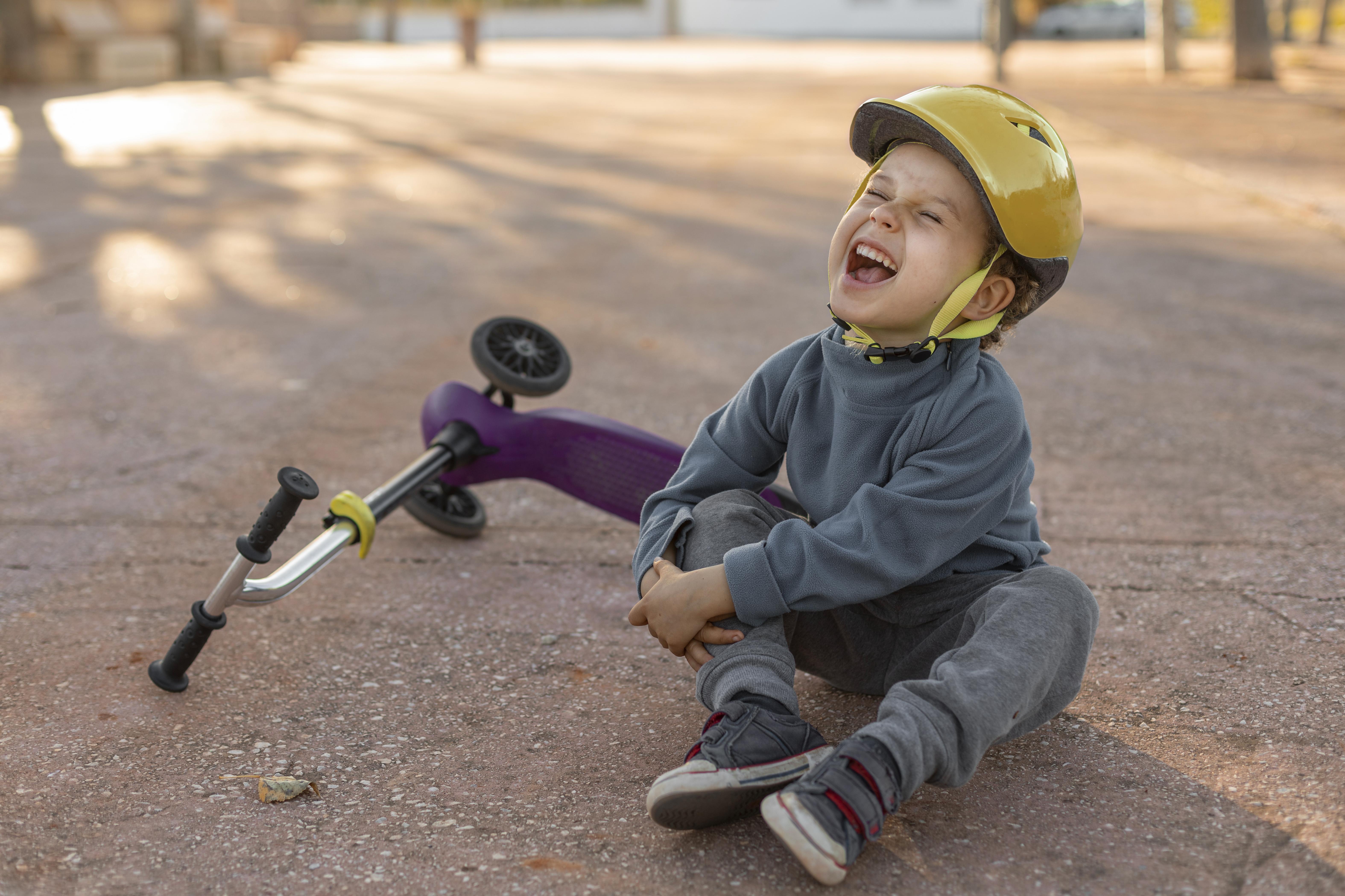 little boy outdoor hurt from scooter