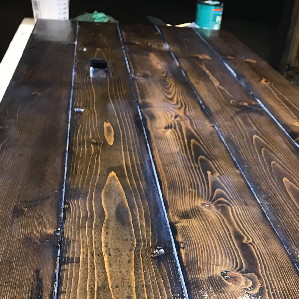 Stained desk with fresh coat of polycrylic applied and still drying.