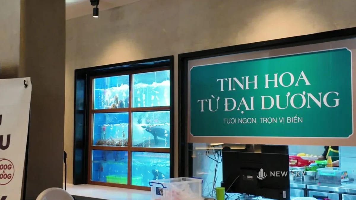 Bể hải sản nhiều ngăn kính, nước sủi bọt; bên phải là ô ra đồ, phía trên ô gắn tấm chữ "TINH HOA TỪ ĐẠI DƯƠNG", bên dưới là mặt quầy.