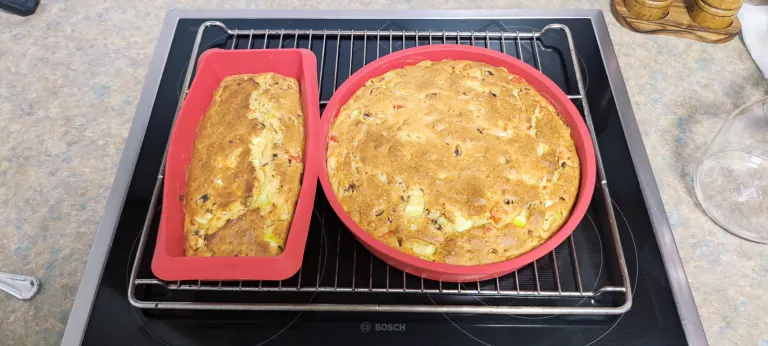 Freshly baked Serbian Carska Pita in silicone baking molds cooling on oven rack with golden brown crust